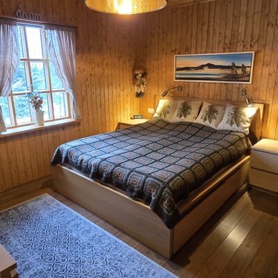 Holzverkleidetes Schlafzimmer mit großem Doppelbett