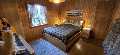 TWood paneled bedroom with large double bed