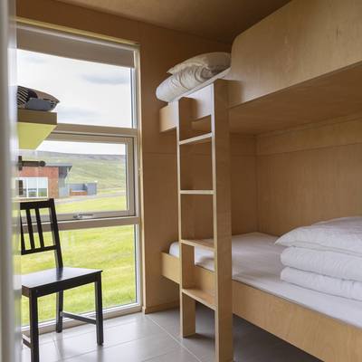 A bright bedroom with a bunk bed and view