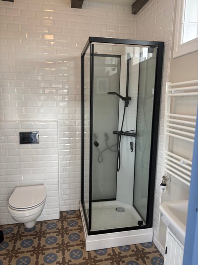 Bathroom with toilet, washbasin and shower cubicle