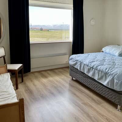 Sehr geräumiges Schlafzimmer mit großem Doppelbett, Schrank und Fenster