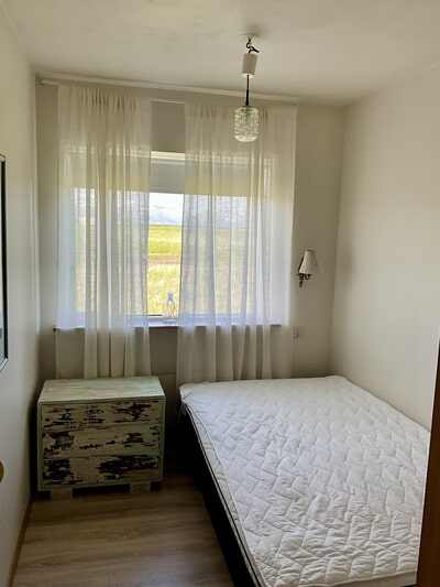 Schlafzimmer mit Einzelbett, Schrank und Fenster
