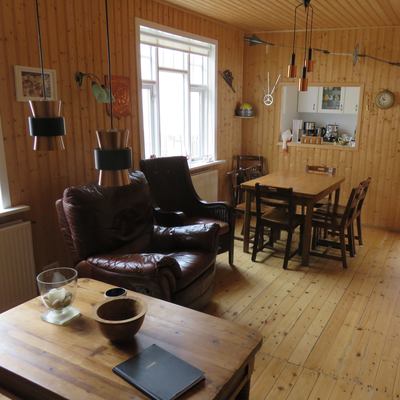 View into the living-dining area with comfortable armchairs and large dining table