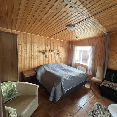 Bedroom with double bed and curtain to the living area