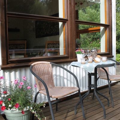 Gartenstühle und ein kleiner Tisch auf der Terrasse um die Gartenblumen zu genießen